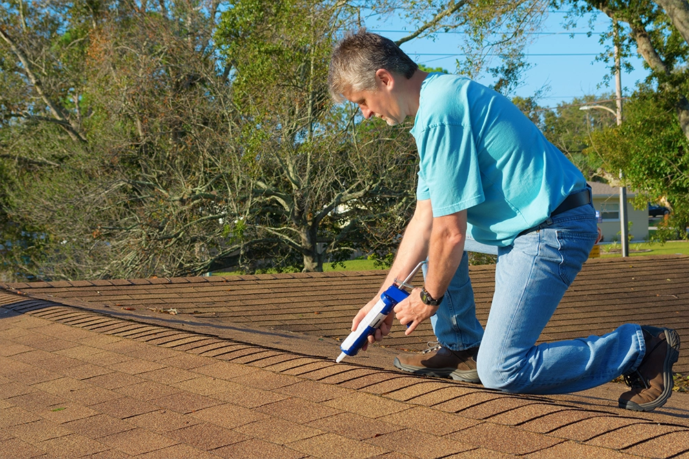 Sealants, repair tape and tools laid out for patching a roof