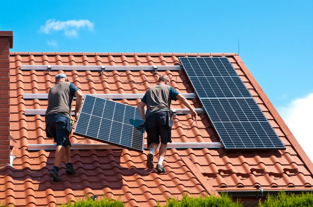 Crew coordinating solar panel removal during a roof replacement project
