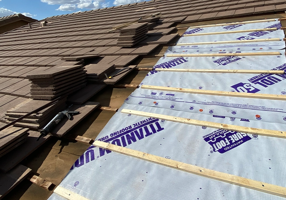 Pulled tiles on a repair showing the underlayment beneath