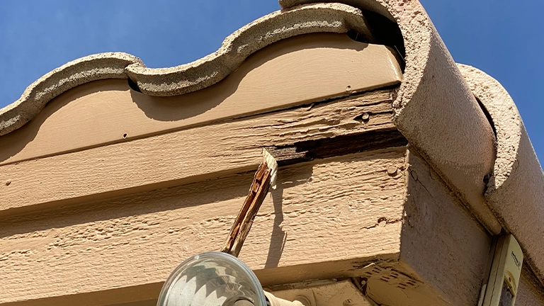 Weathered and deteriorating wood around roof eaves from long term sun exposure