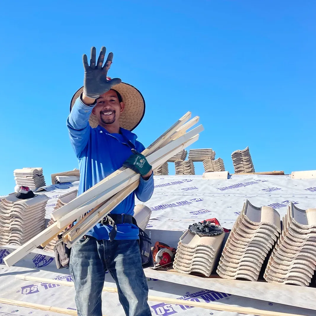 White Leaf Roofing crew member waving from a tile roof job in the East Valley