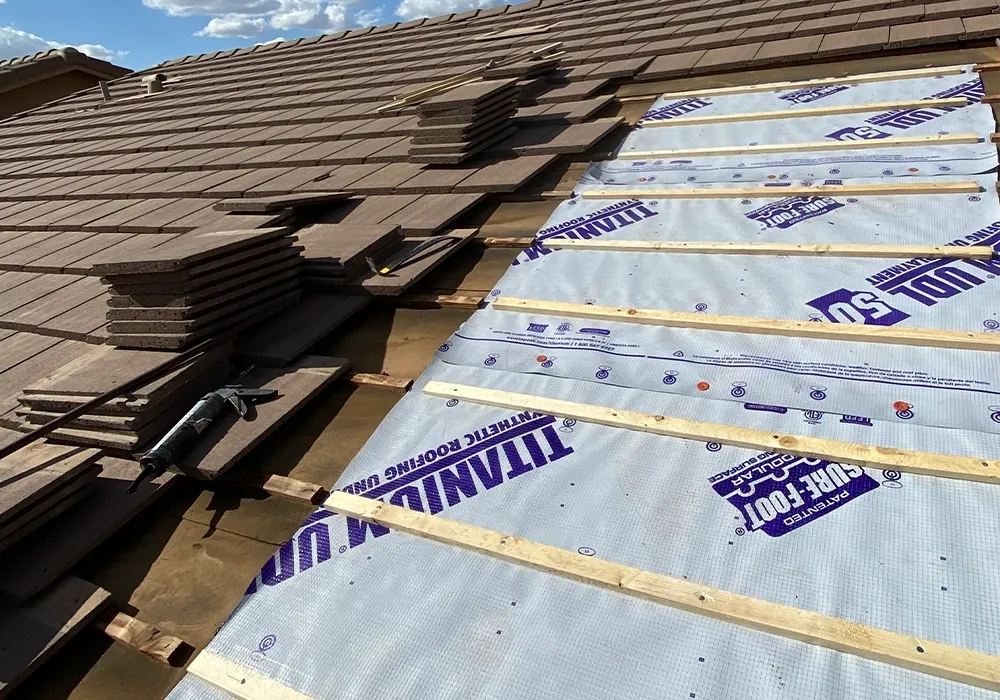 Tile roof with tiles lifted to expose failed underlayment on an East Valley home